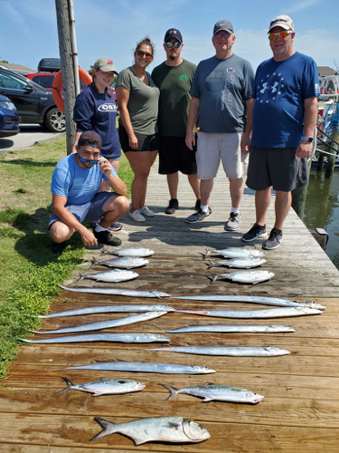 family of six people standing on the dock. nine ribbonfish (silver eel like fish) two spanish macks and six albacore in the eight pound size
