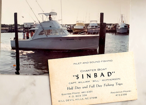 Picture of a white sided sportfisher with old fashioned canvassed top . pulling into the marina . old business card on top of the photo from thirty years ago