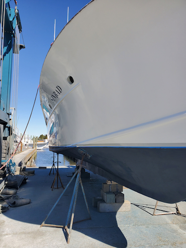 picture of the side of the charter boat sinbad. white shiny sides and fresh blue paint on the bottom